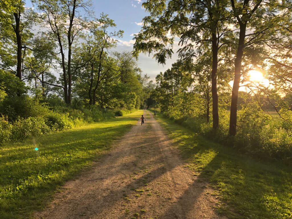 A child runs down a wooded path at Lake Farm County Park.