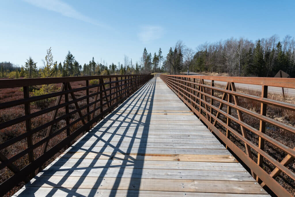 An empty boardwalk with metal railings on the Heart of Vilas Trail near Boulder Junction, Wisconsin.