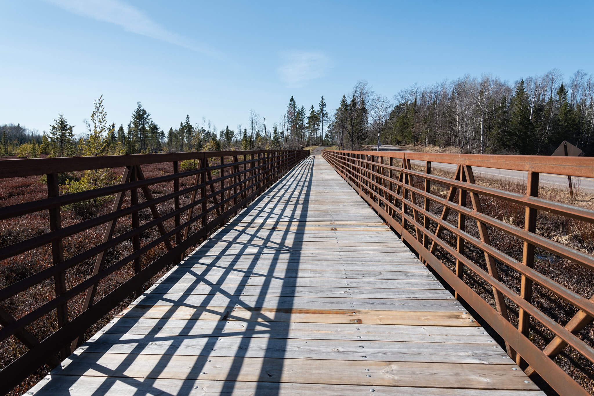 An empty boardwalk with metal railings on the Heart of Vilas Trail near Boulder Junction, Wisconsin.