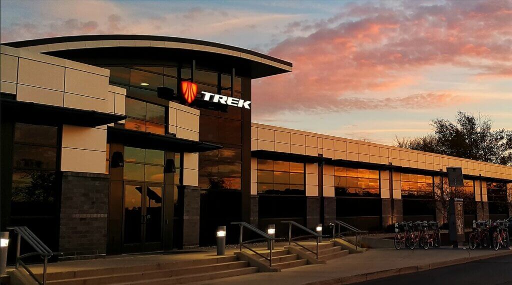 An office building with the Trek logo and several bikes parked out front.