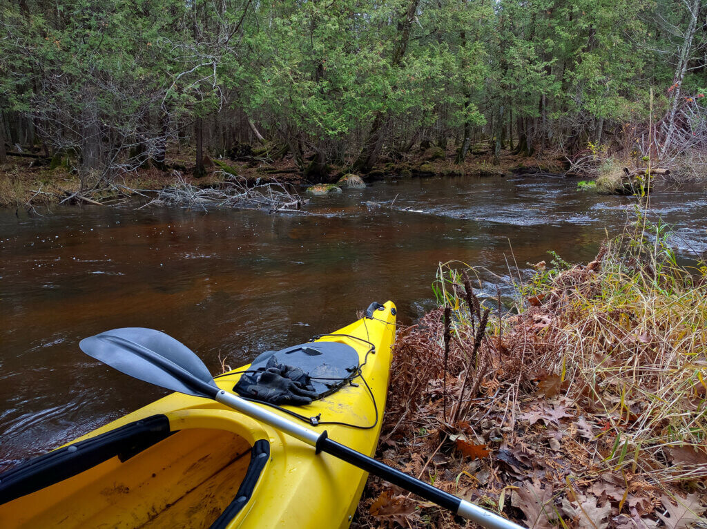 A kayak sits on the bank of the Little Wolf River