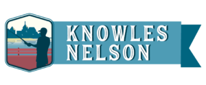 Knowles-Nelson Stewardship logo horizontal blue logo with a graphic of a fisherman on the left.