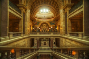 A photo looking down a grand staircase in the Wisconsin Capitol building with a vaulted ceiling in the background.
