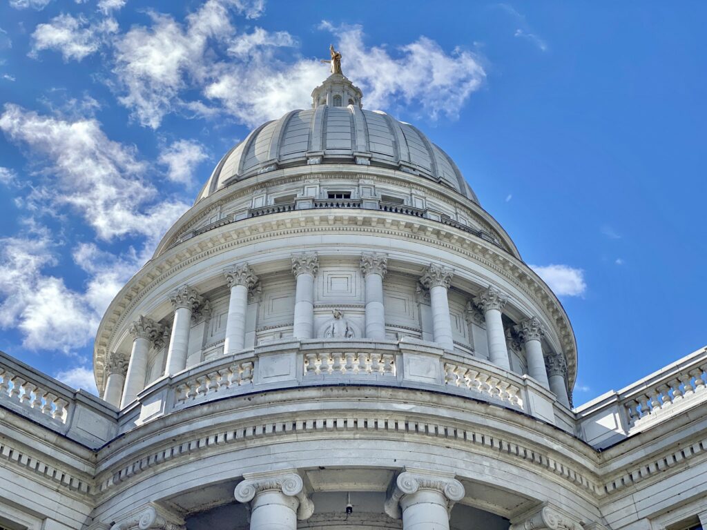 Exterior of the Wisconsin state capitol building's rotunda against blue sky.