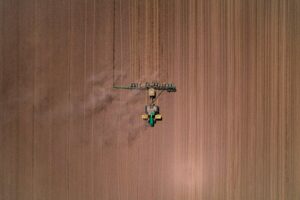 An aerial view of a tractor plowing a field.