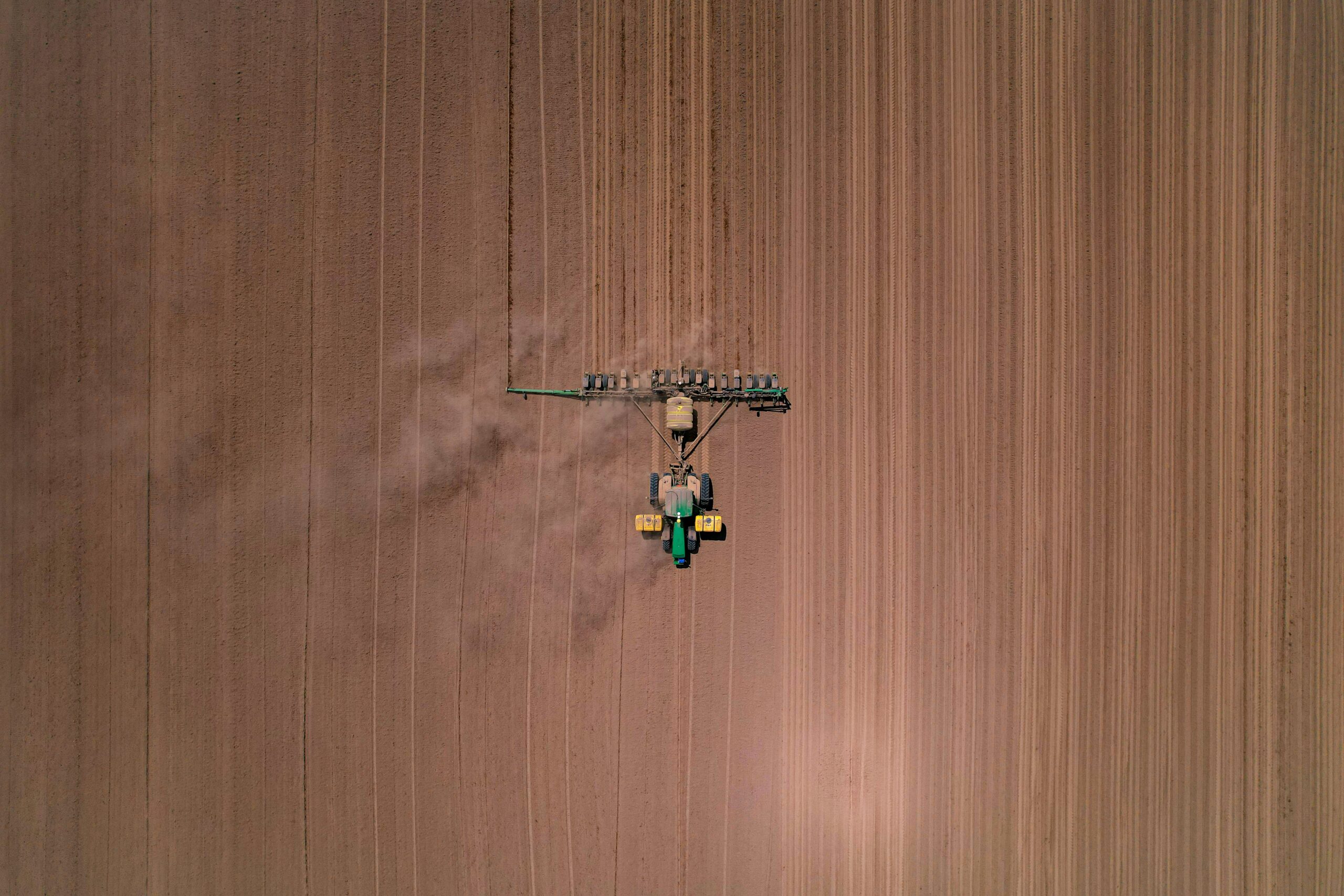 An aerial view of a tractor plowing a field.