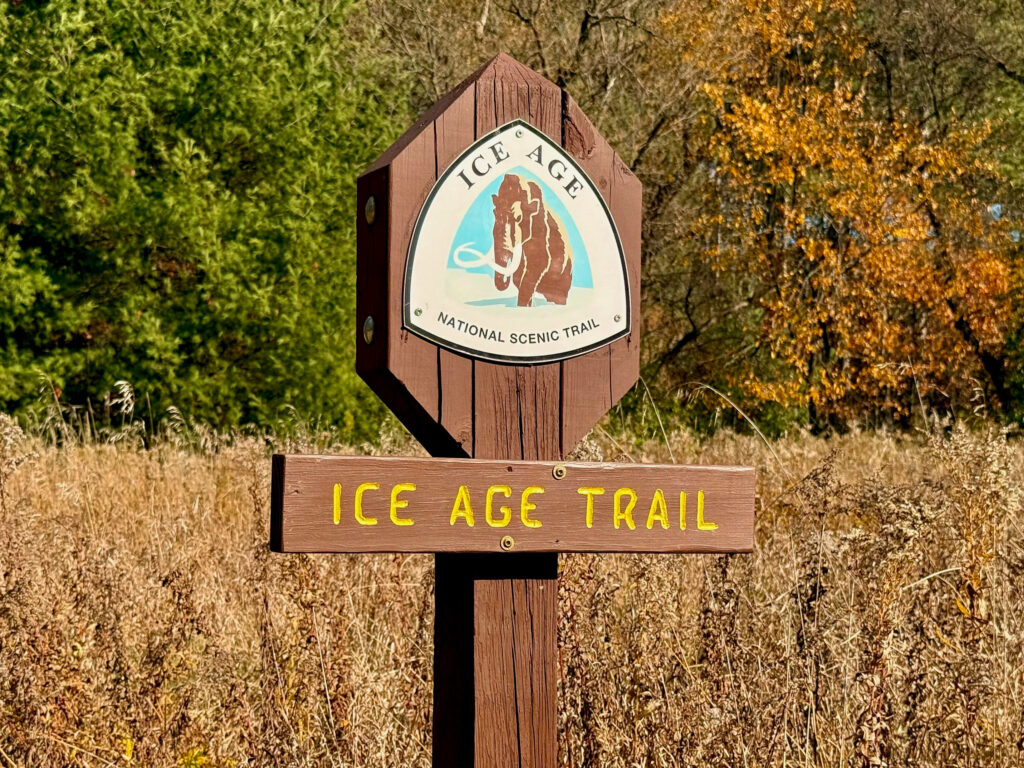 Photo of an Ice Age Trail sign against fall foliage.