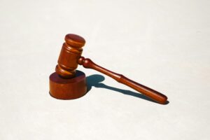 Brown wooden gavel on a white surface.