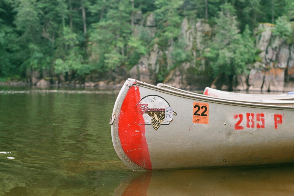 Red and white canoe on a lake during daytime.